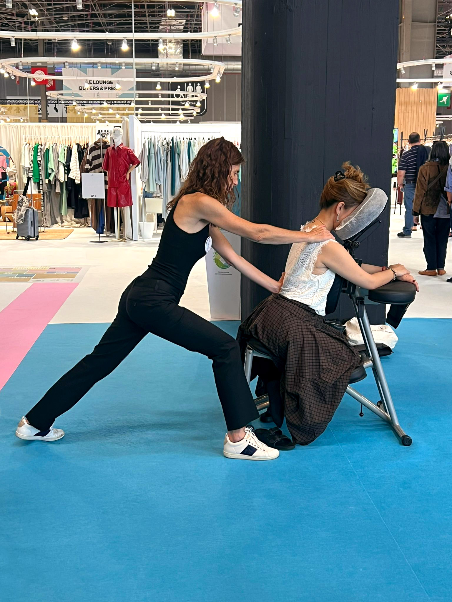 Cécile Geoffroy réalisant un massage Amma Assis sur chaise lors d'un salon professionnel